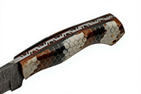 Close-up of a Damascus Rattler Snakeskin Texas Hunter knife with rattlesnake handle and file-work on a white background