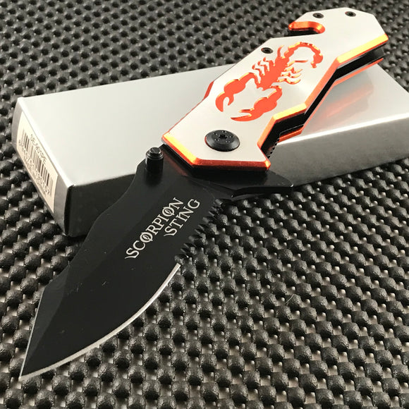 Folding pocket knife featuring half serrated blade and aluminum blade with orange scorpion design