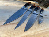 Set of four Damascus steel kitchen chef knives with Damascus steel blades and wooden handle on a wooden surface