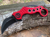  Tac-Force spring assisted karambit knife with red skeletonized handle and black hawkbill blade.