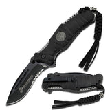 "Open MTech M-A1020BK knife showing black serrated blade, USMC logo, and skull lanyard"