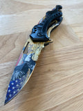Folding pocket knife with USA American Flag Bald Eagle & We the People Design on the blade blade sitting on a wooden surface