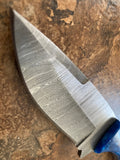 Damascus sapphire blue camel bone knife's Damascus steel blade on a brown tile