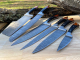 Set of six Damascus steel kitchen knives on a wooden surface with a natural background.