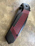 Black and red folding knife on a textured surface