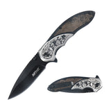 Open MTech USA MT-A2006BB knife showing black blade and intricate floral etching on wood and silver handle.